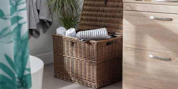 A willow storage chest placed in a bathroom. 